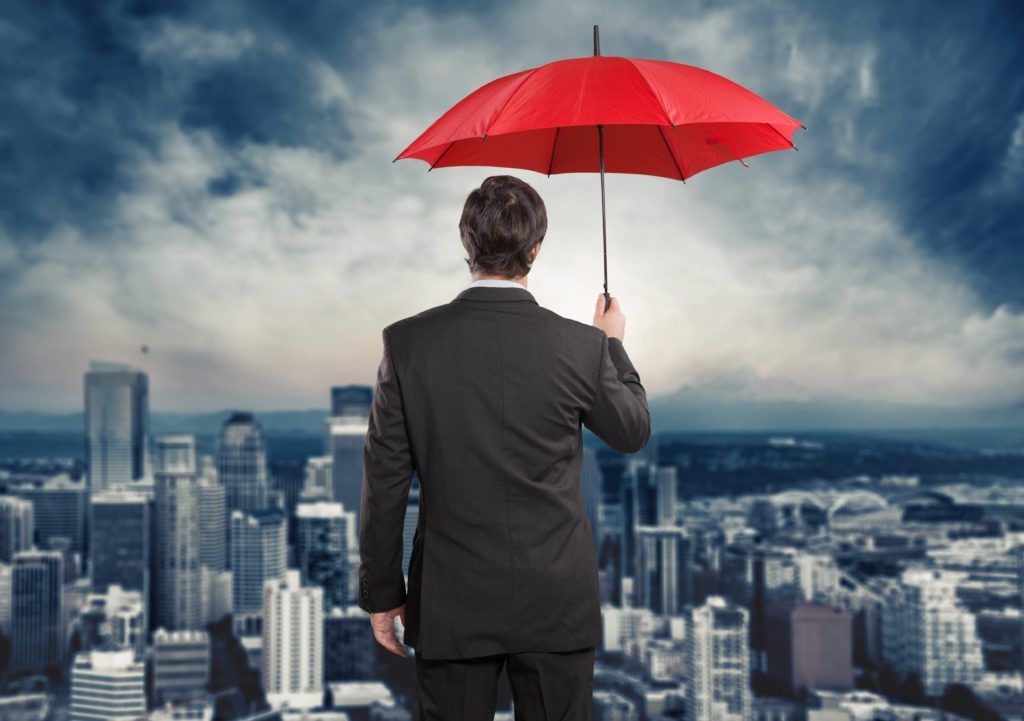 Man holding umbrella with view of city