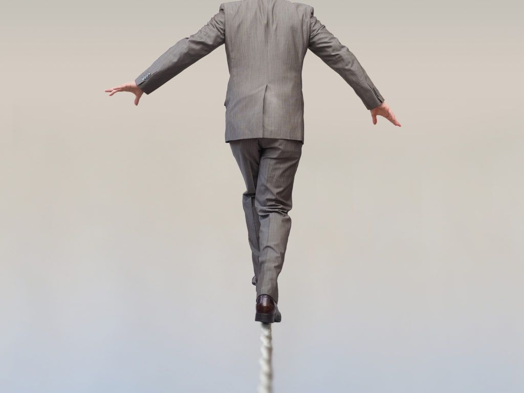 Man in Suit Balancing on Pole